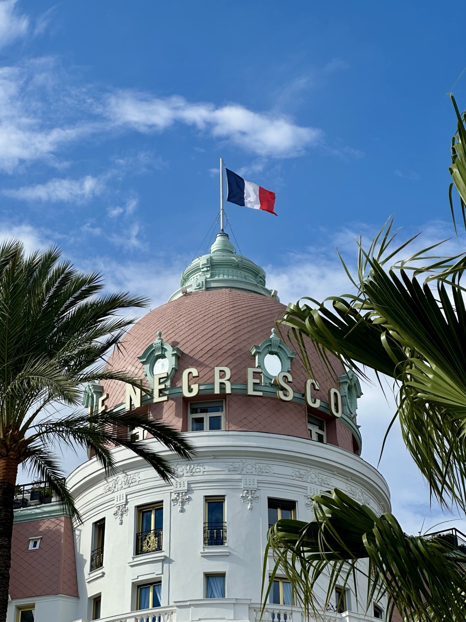 The French flag flies in the wind above Le Negresco Hotel